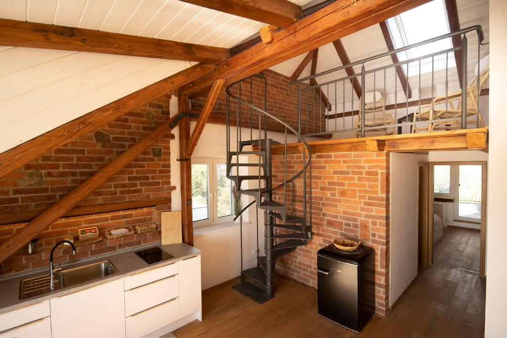 cocina con pared de ladrillo y escalera de caracol en Mezonetový apartmán 2 u rybníka, en Olomouc