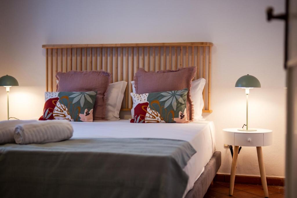 een slaapkamer met een groot bed met twee kussens bij Casa Porta da Vila in Óbidos