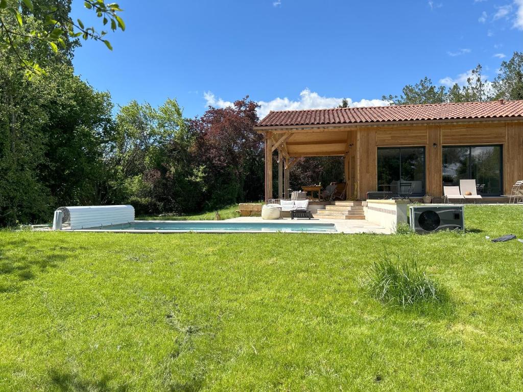 ein Haus mit einem Pool in einem Garten in der Unterkunft Maison de campagne à Montignac-Lascaux in Montignac