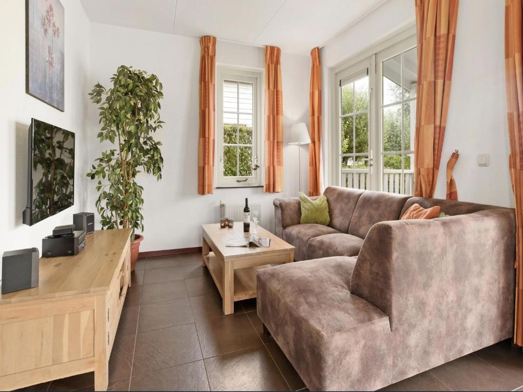 a living room with a couch and a table at Bungalow by Water near Rotterdam and Zeeland in Simonshaven