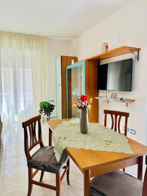a dining room table with a vase of flowers on it at La casa di Biu in Gela