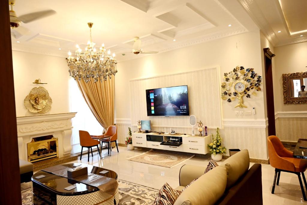 a living room with a couch and a tv at Spanish House, DHA-6, Raya Golf and Fairways Commercial in Lahore