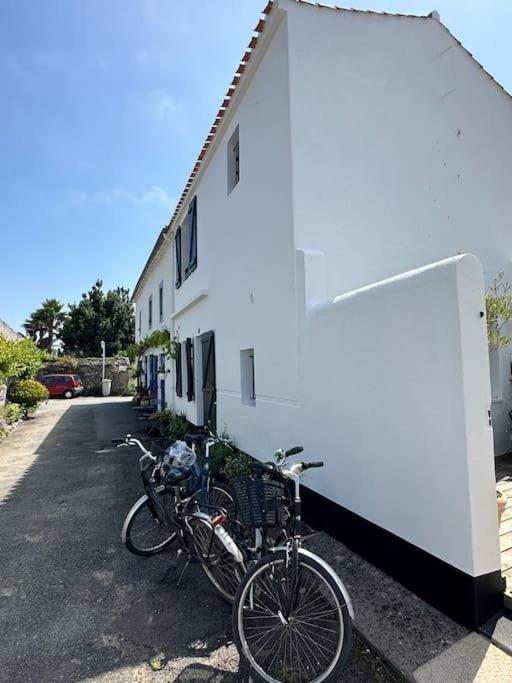 un vélo garé à côté d'un bâtiment blanc dans l'établissement Maison pecheur dans le banzeau, à Noirmoutier-en-l'lle