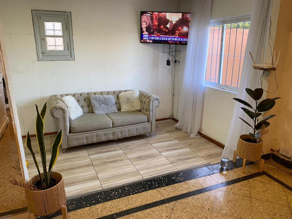 a living room with a couch and a tv at Chalet Mar del Plata in Mar del Plata