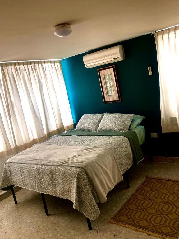 a bedroom with a bed with a blue wall at Luna Llena in Monterrey