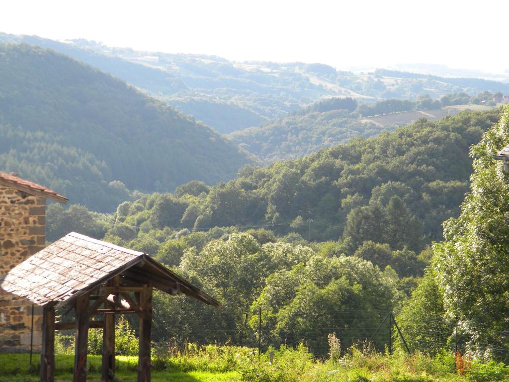 Blick auf ein Tal von einem Hügel mit einem Gebäude in der Unterkunft Domaine Du Randier in Ferrières-sur-Sichon