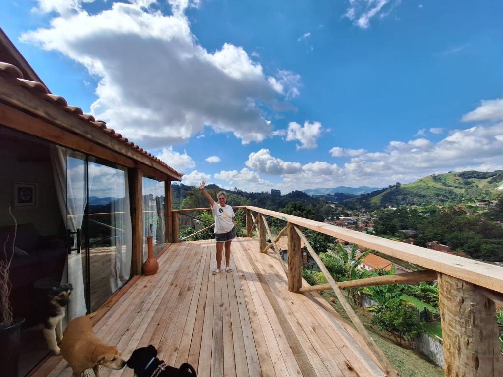 a woman is standing on a wooden deck at Charmosa Cabana Passarim, Gonçalves, Costas in Paraisópolis