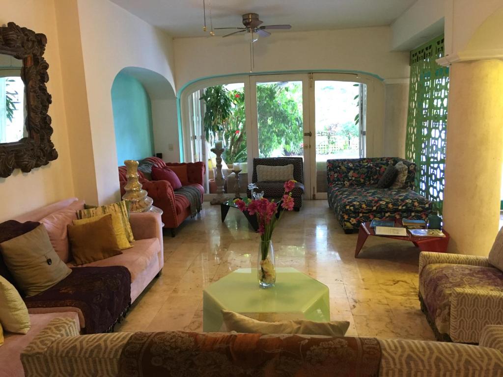 a living room with couches and a table with flowers on it at La Villa du Golf à Cancun Hotel Boutique in Cancún