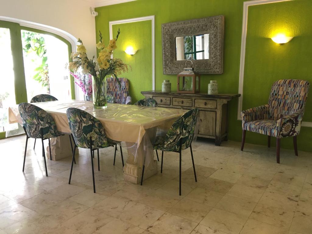 a dining room with a table with chairs and a mirror at La Villa du Golf à Cancun Hotel Boutique in Cancún