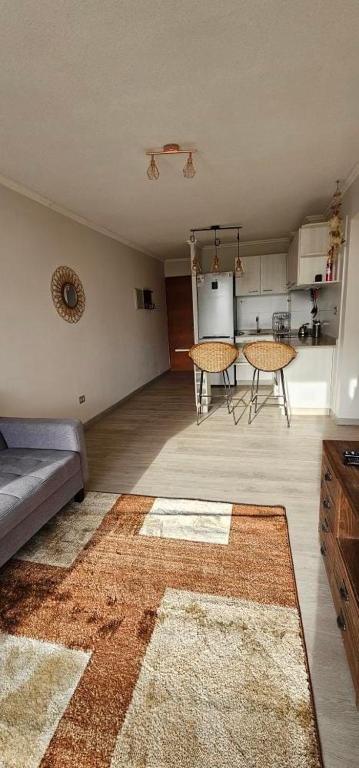 a living room with a couch and a kitchen at Departamento Pelluco Puerto Montt in Puerto Montt