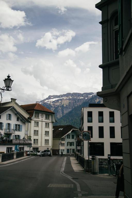 uma rua da cidade com edifícios e uma montanha ao fundo em Nimbuzzz Apartments em Unterseen