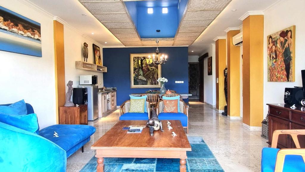 a living room with a blue couch and a table at Apartment Nine at the Bayshore Resort Candidasa in Candidasa