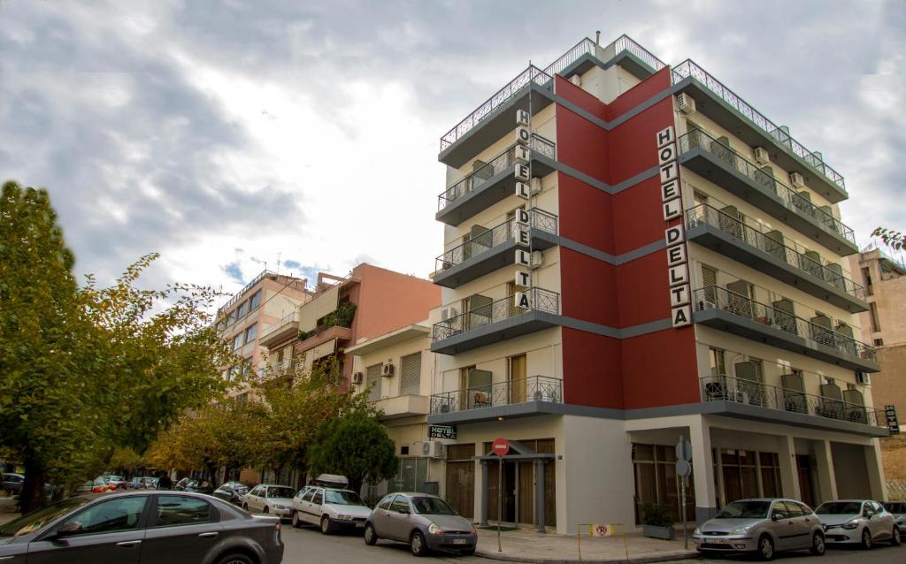 un edificio rojo con coches estacionados frente a él en Athens Delta Hotel, en Atenas