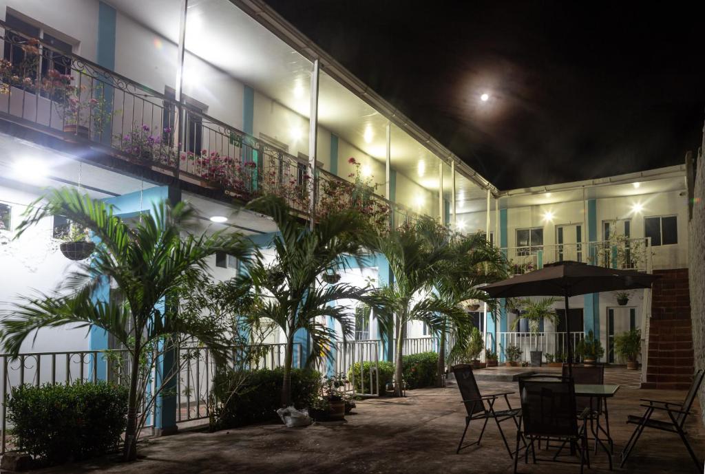 a courtyard of a building with a table and palm trees at Palaa Mujuii Hotel in Dibulla