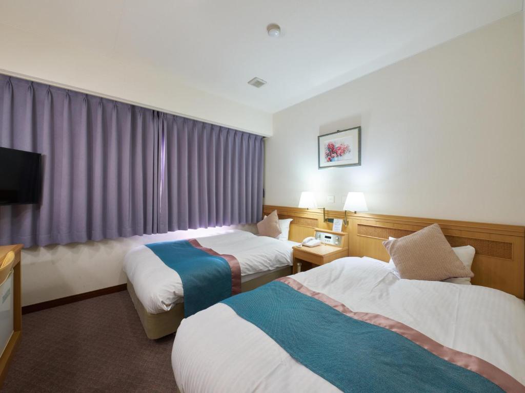 Postel nebo postele na pokoji v ubytování Hotel Areaone Wadayama