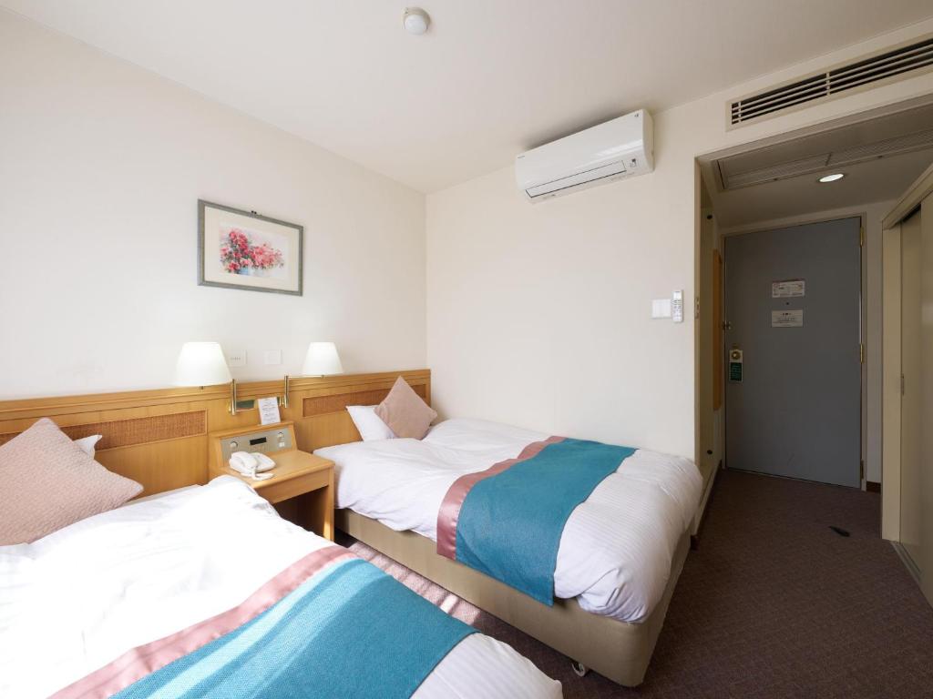 Postel nebo postele na pokoji v ubytování Hotel Areaone Wadayama