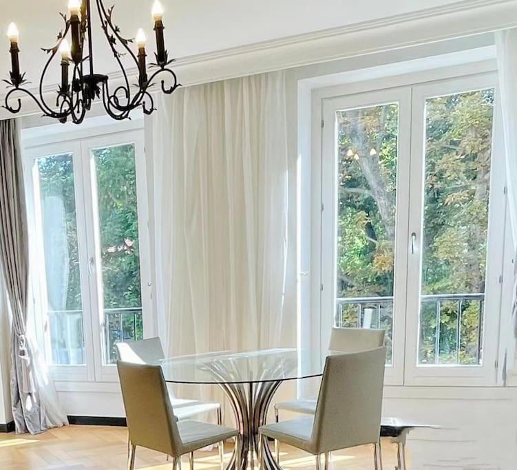 une salle à manger avec une table et des chaises en verre dans l'établissement Elégant 4 pièces au coeur du Paris artiste, à Paris