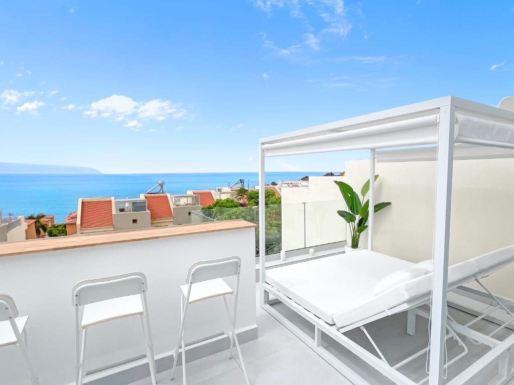 een balkon met een bar met stoelen en de oceaan bij Luxury 3-BDR Families & Friends Villa Ocean View in Puerto de Santiago