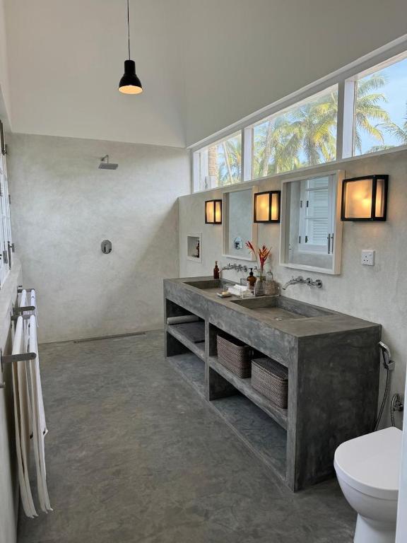 a large bathroom with a sink and a toilet at Arabella on Boossa in Galle