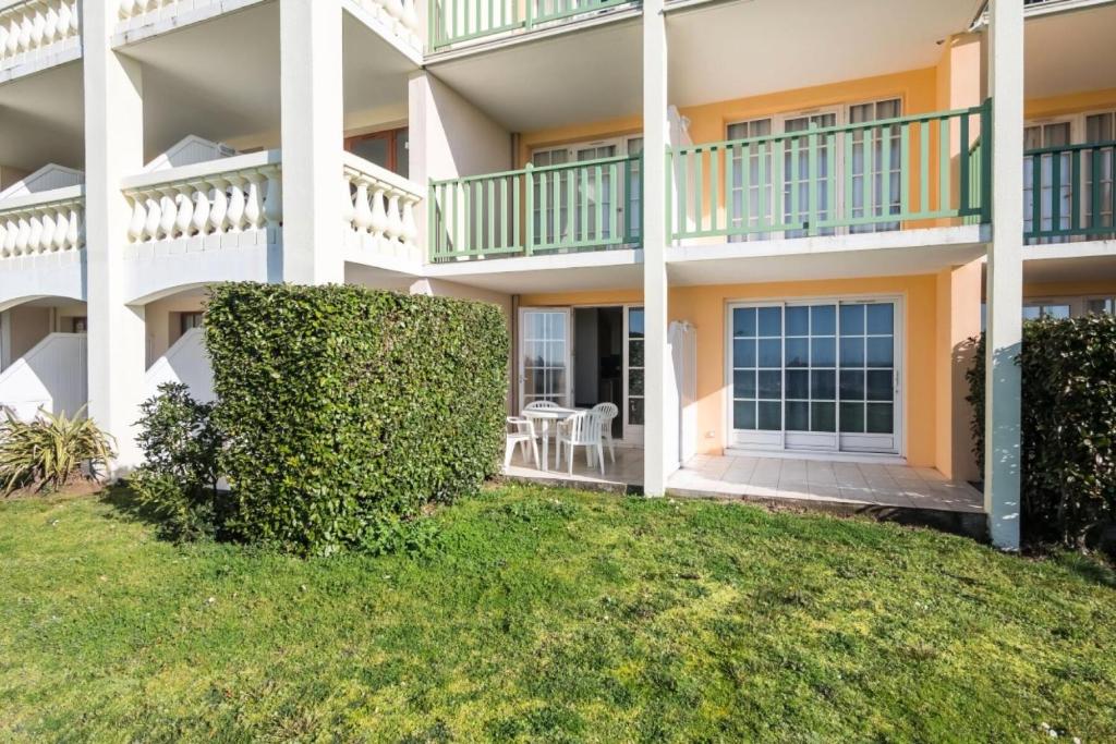 un immeuble d'appartements avec une pelouse verte en face de celui-ci dans l'établissement Résidence Port Bourgenay - maeva Home - Studio 4 personnes - Sélection MAE-8606, à Talmont-Saint-Hilaire