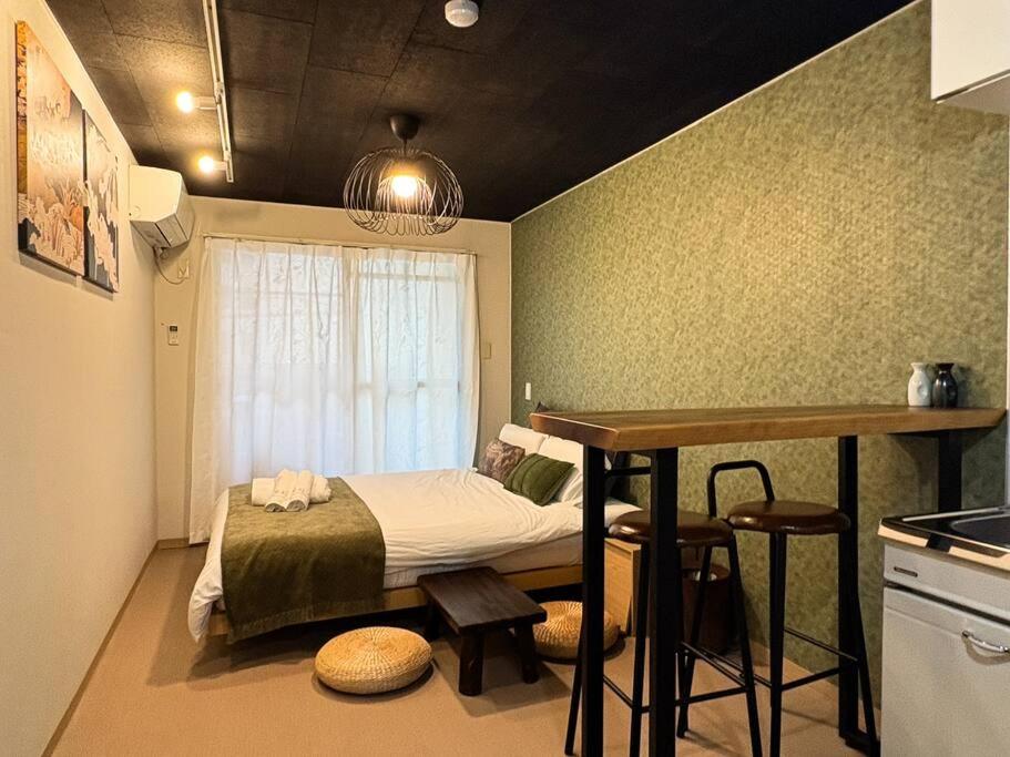 une chambre avec un lit et une table et une cuisine dans l'établissement Campass202 1 minute from subway no elevator city center Freewifi, à Osaka