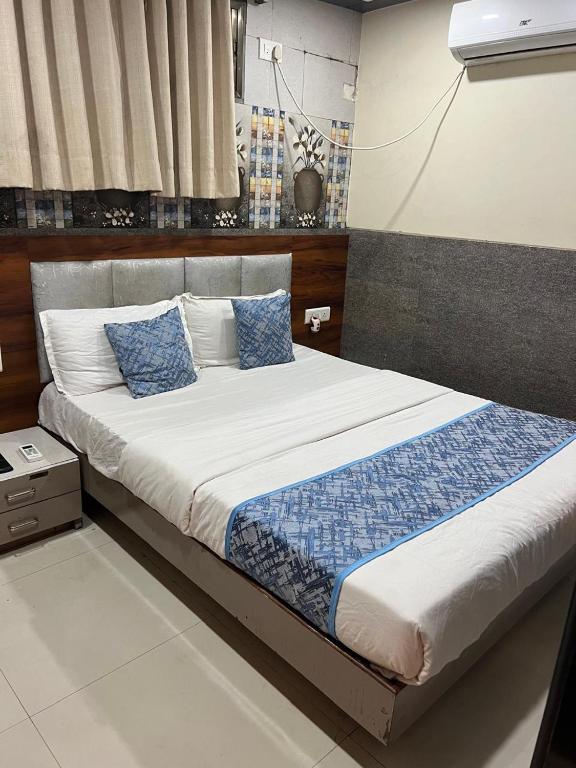 a bedroom with a large bed with blue pillows at Hotel KF Residency in Mumbai