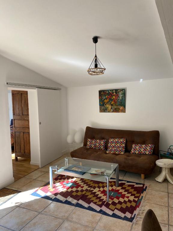 un salon avec un canapé et une table en verre dans l'établissement Gîte cosy, à Orange