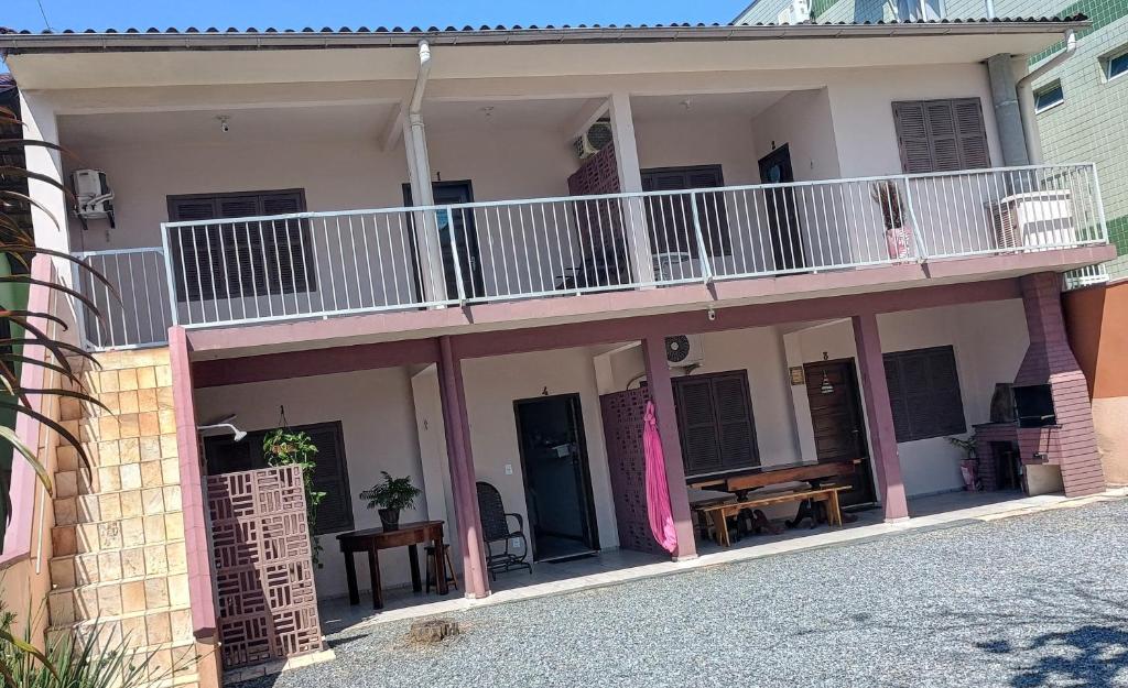 a house with a balcony with a table on it at Aptos Enseada Prox Praia in São Francisco do Sul