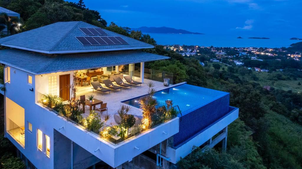a house with a solar roof with a swimming pool at Baan Kuno 5BR Private Villa with Panoramic Views in Bophut