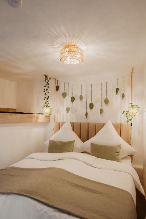 a bedroom with a large bed and a chandelier at JASTA Homes Mosel, zentral, Netflix, Waschmaschine, Terrasse, Privateingang, Erdgeschoss, ältester Weinort Deutschlands in Neumagen-Dhron