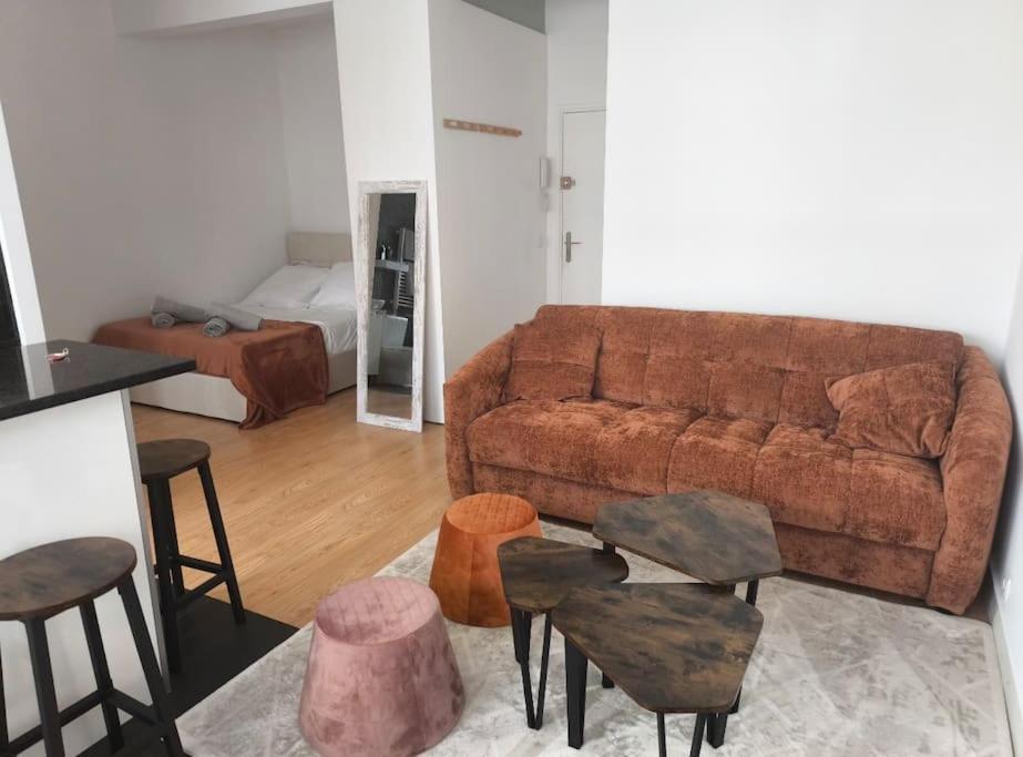 - un salon avec un canapé, des tables et des chaises dans l'établissement Studio pour 1 à 4 pers localisé dans un quartier chic, à Paris