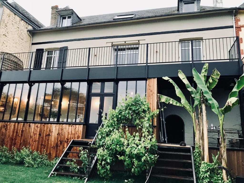 Elle offre une vue sur l'extérieur d'une maison dotée de grandes fenêtres. dans l'établissement Grande Maison en bord de Seine, 1h 15de Paris, à Muids