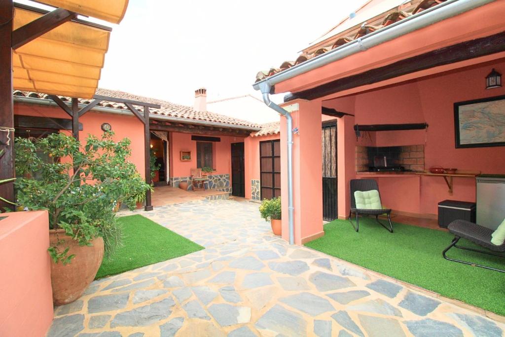a patio of a house with a yard with grass at Casa de la Jara by SIERRA VIVA in La Nava