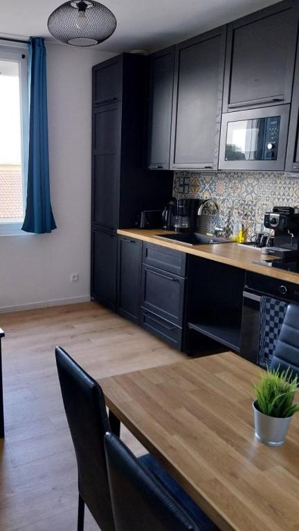 une cuisine avec des armoires noires et une table en bois dans l'établissement 