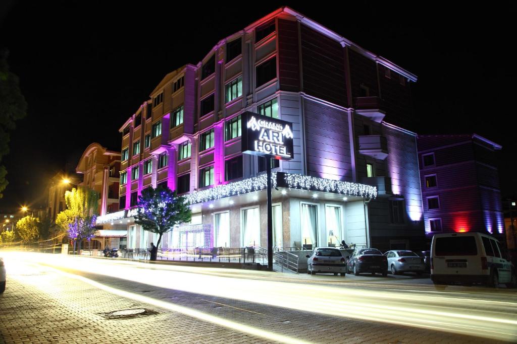 un edificio con iluminación púrpura en una calle de la ciudad por la noche en Afyon Grand Ari Hotel en Afyon