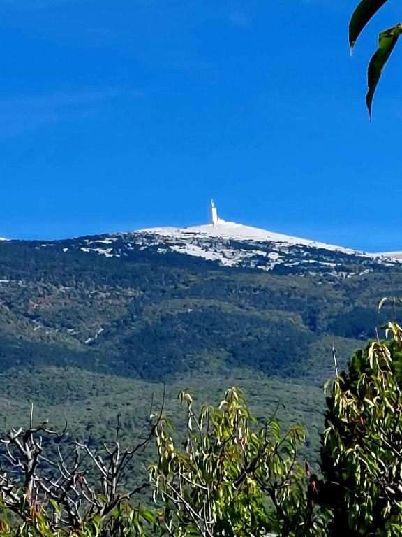 une colline avec un phare au sommet d'une montagne dans l'établissement La LiMonade de FraCri, à Crestet