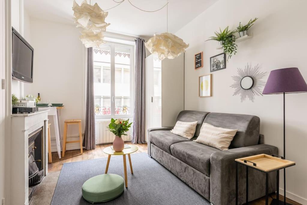 un salon avec un canapé et une table dans l'établissement Appartement moderne et calme, à Lyon