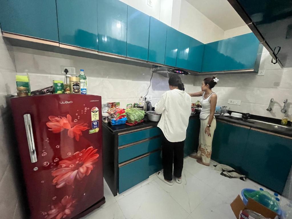 a man and a woman preparing food in a kitchen at Marina Home Stay in Bodh Gaya