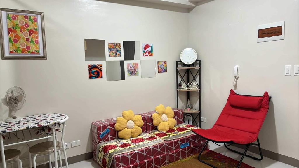 a living room with a couch and a red chair at Solana Tower 1 New and Very Neat Studio Unit near SM Manila in Manila