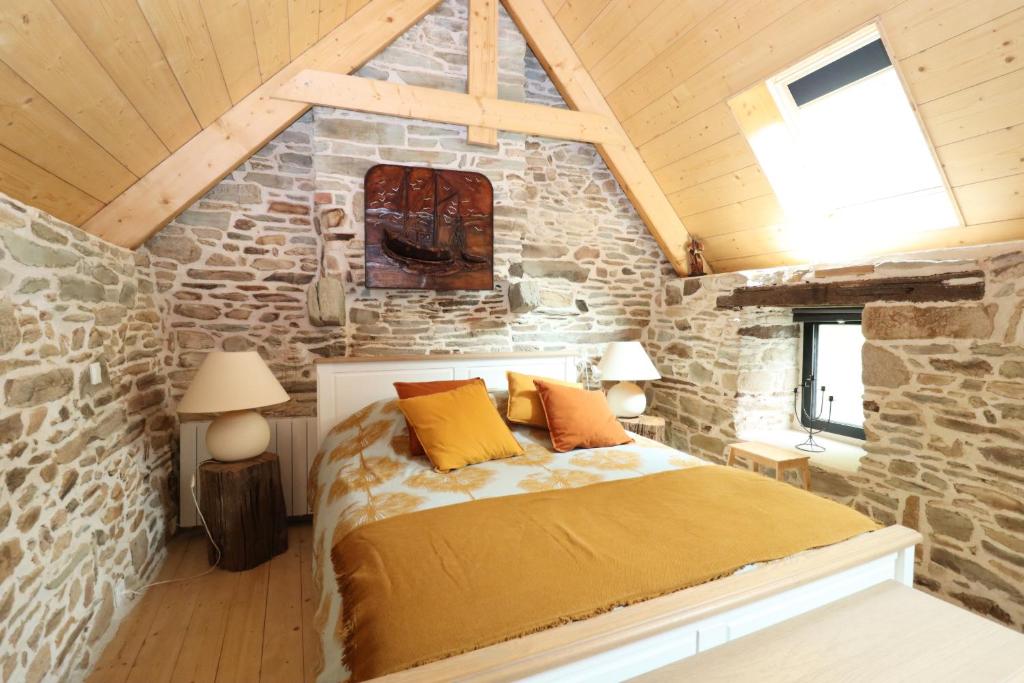 una camera da letto con un letto in un muro di pietra di Au cœur du quartier historique a Lannion