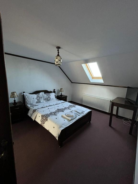 a bedroom with a large bed with a window at Plaiul Bucovinei in Horodnic de Sus
