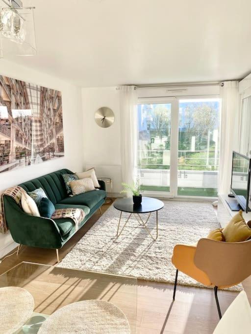 un salon avec un canapé vert et une table dans l'établissement Le Domaine Réservé , parking et écrin de verdure, à Amiens