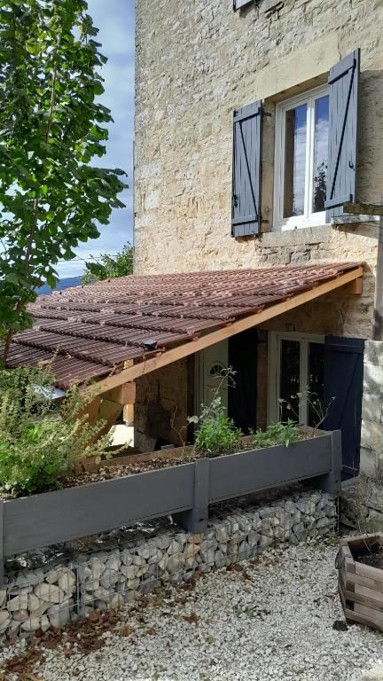 a building with a window and a wooden roof at Maison rénové en pierre in Crotenay