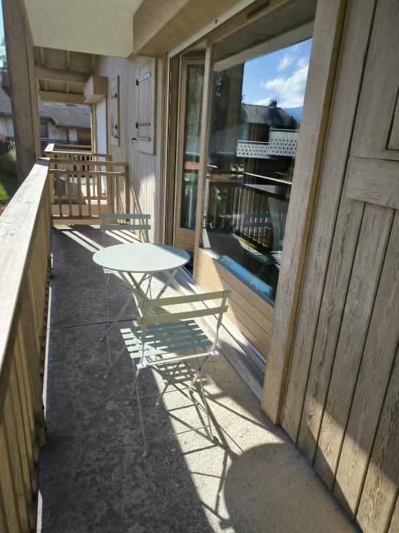 une table et des chaises assises sur le côté du bâtiment dans l'établissement Apt or chalet near the slopes Megève, à Megève