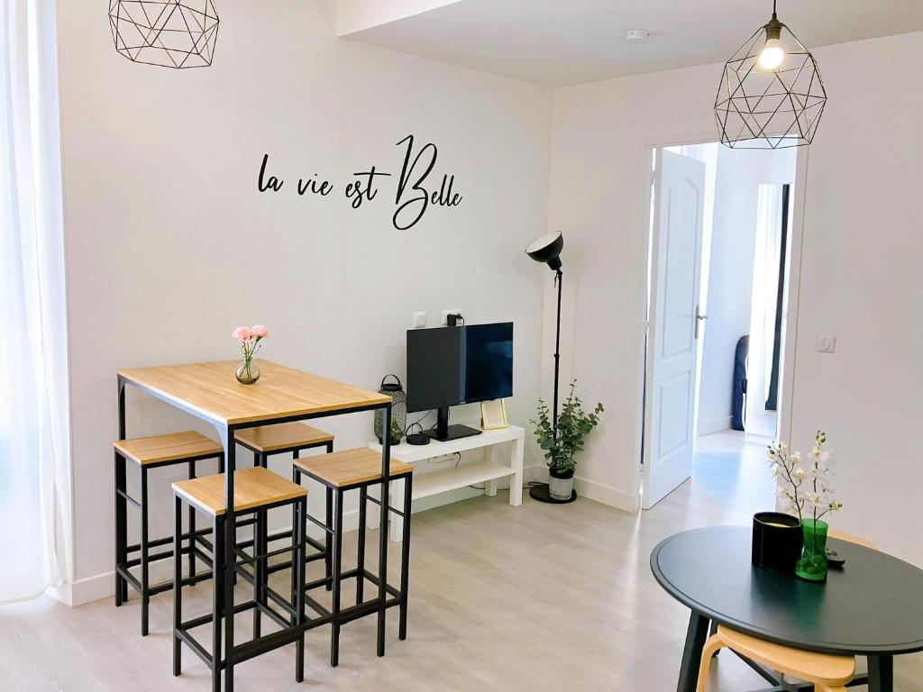 un salon avec une table et une télévision dans l'établissement La vie est belle entre Disneyland et Paris, à Lagny-sur-Marne