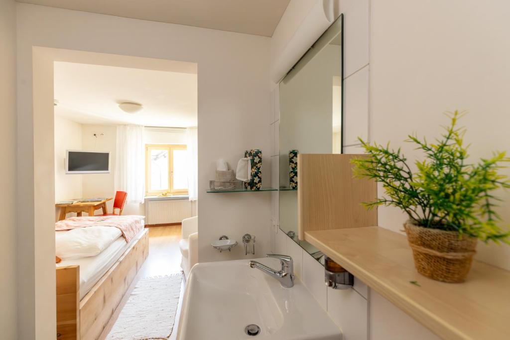 a bathroom with a sink and a bed in a room at Palazzo Mysanus Samedan in Samedan
