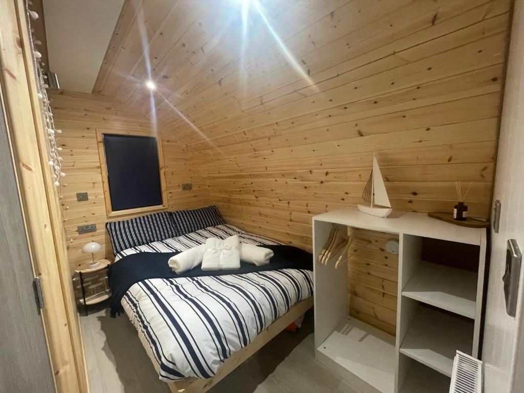 Piccola camera con letto in una cabina di legno. di Tra na Mbó Glamping Pod a Waterford