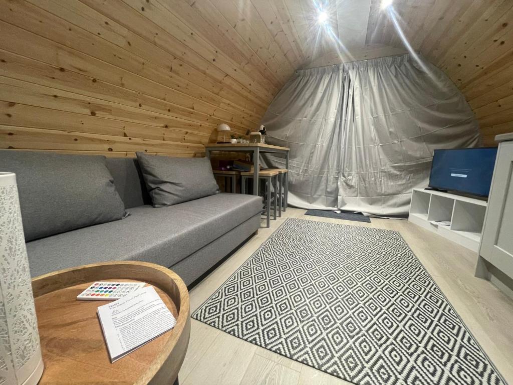 un soggiorno con un divano e un tavolo di Tra na Mbó Glamping Pod a Waterford