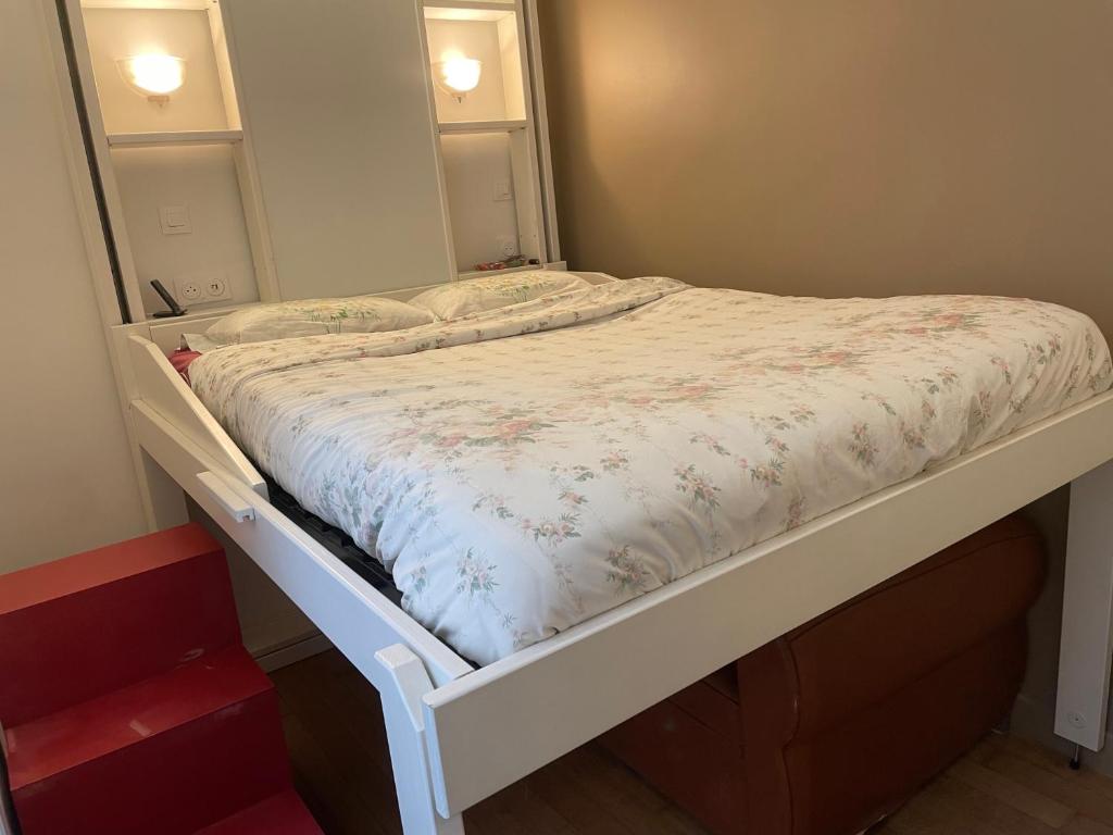 Ce lit se trouve dans un dortoir doté d'un cadre de lit blanc. dans l'établissement Appartement au cœur de Paris, à Paris