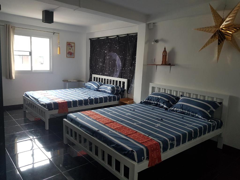 a bedroom with two beds and a star on the wall at Jay Jay Guesthouse in Bangkok